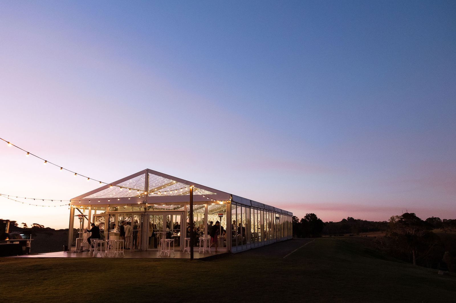 The marquee at Rosewood Estate, La Boscosa's sister venue, lit at dusk with guests inside